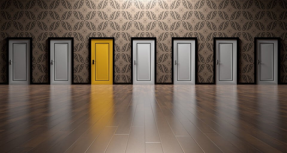 A row of white doors with one yellow one